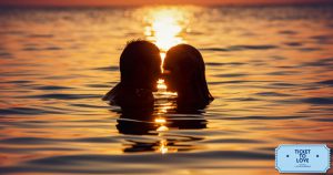Posti dove fare l'amore: una coppia si bacia nell'acqua del mare al tramonto