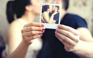 Giornata Mondiale del Bacio: una coppia si bacia tenedo in mano una polaroid che ritrae il bacio